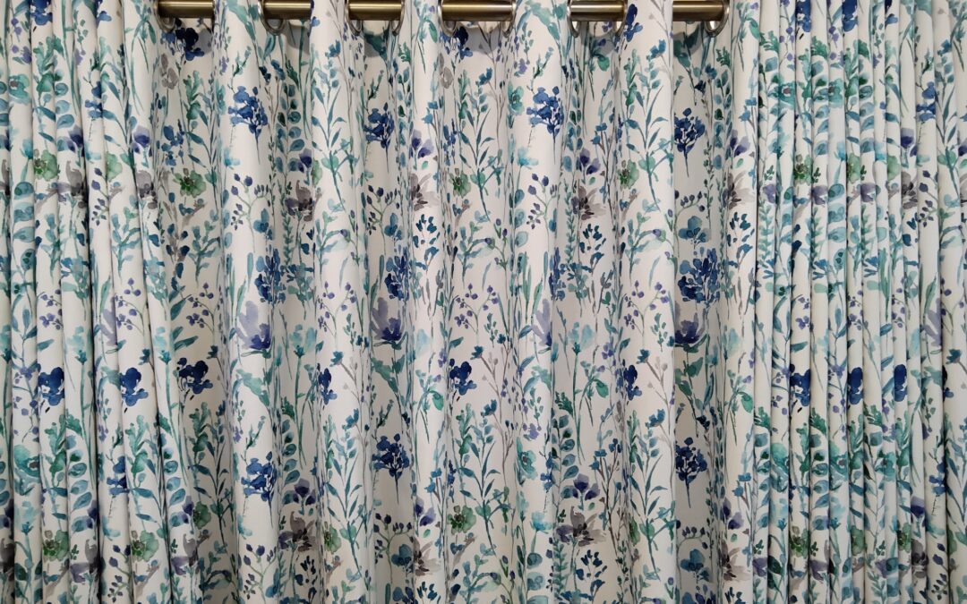 Blue and green floral eyelet curtains with brass curtain pole