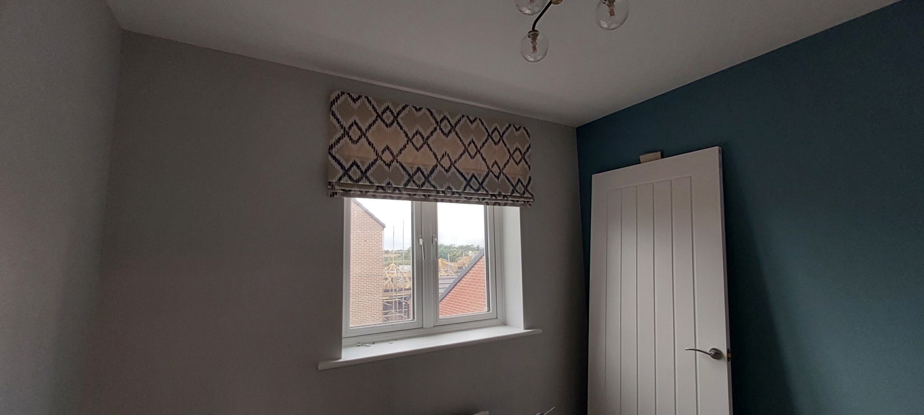 Patterned Roman blind fitted to a bedroom window