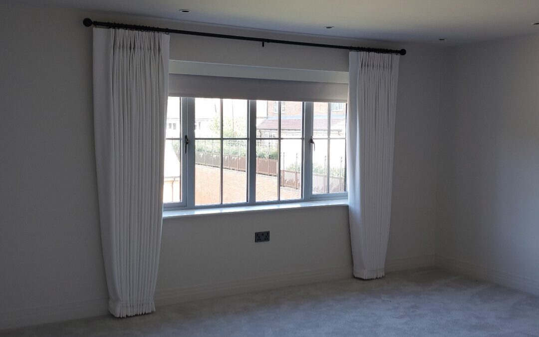 Blue floral eyelet curtains on brass curtain pole
