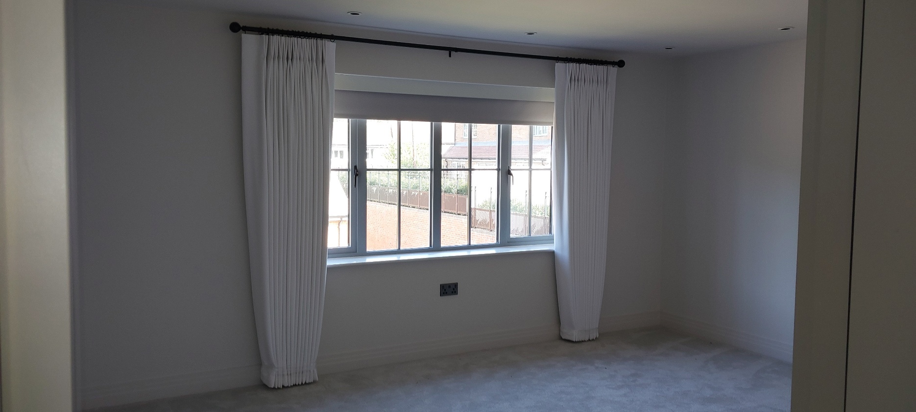 Blue floral eyelet curtains on brass curtain pole